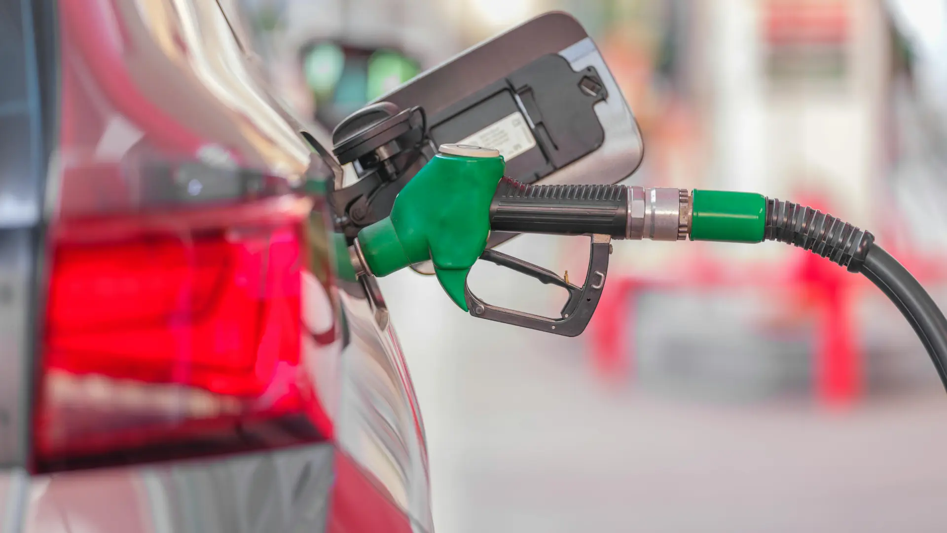 Pistol de alimentare introdus în rezervorul unei mașini, simbolizând consumul eficient de combustibil.